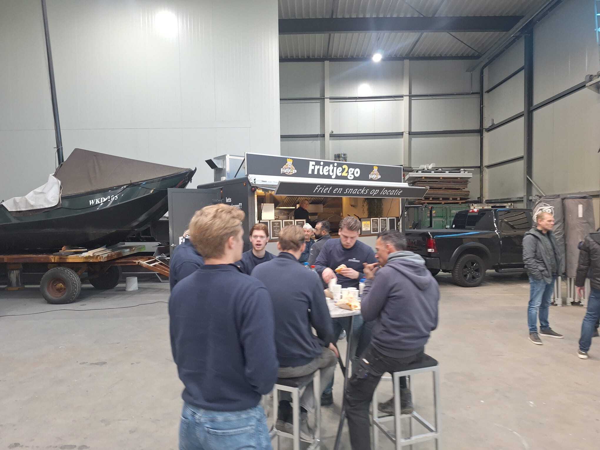 Gasten genieten van friet op locatie bij de Frietje2go foodtruck in Dordrecht